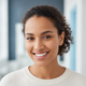 Smiling woman in her late 20s looking at the camera, a trustworthy and friendly portrait.